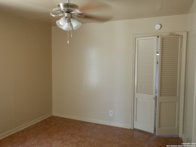 tiled spare room with ceiling fan