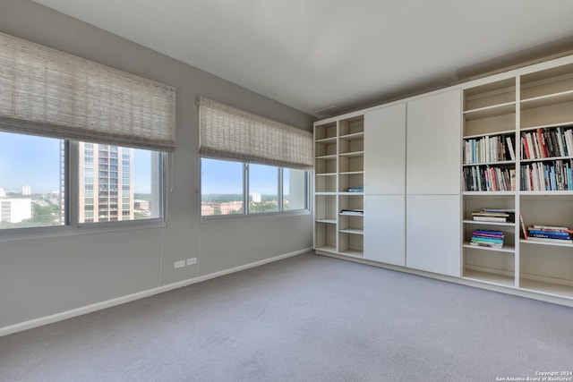 carpeted spare room with visible vents and baseboards