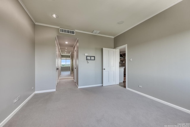 empty room with carpet flooring, baseboards, visible vents, and ornamental molding