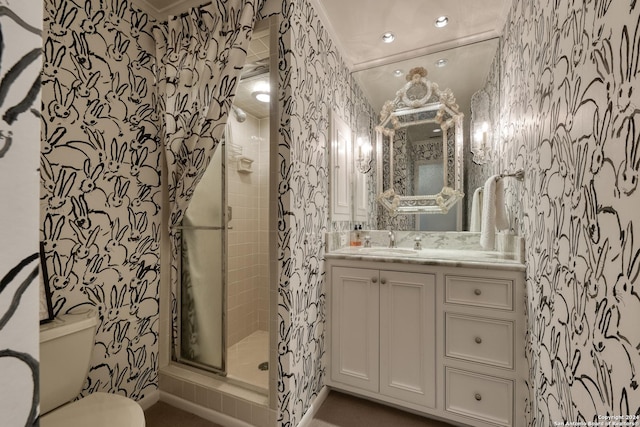 bathroom featuring a stall shower, toilet, vanity, and wallpapered walls