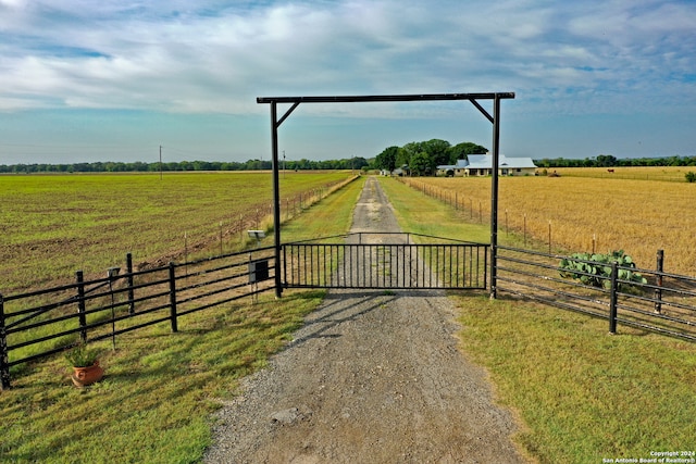 view of gate with a rural view and a yard