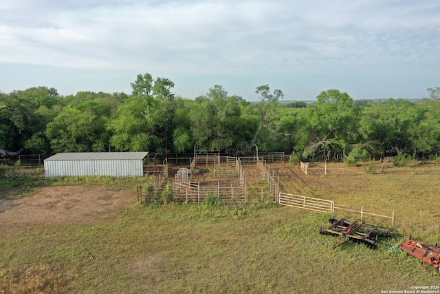 view of yard with an outdoor structure and a rural view