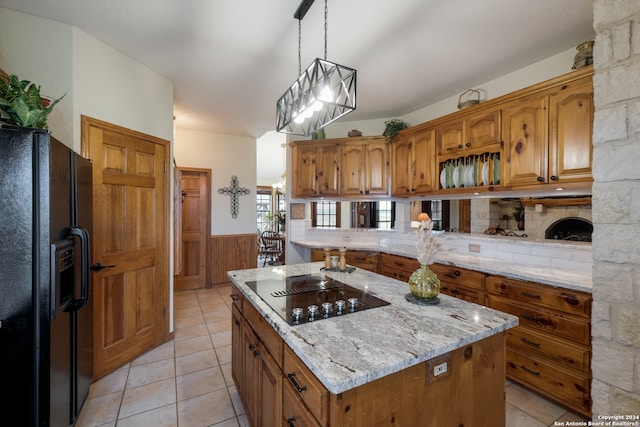 kitchen with hanging light fixtures, a kitchen island, black appliances, tasteful backsplash, and light tile flooring