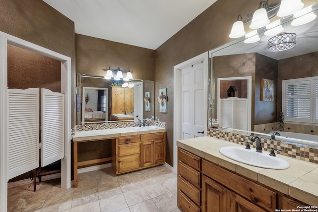 bathroom with tiled bath, tile floors, and large vanity