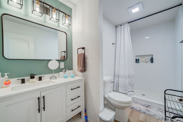 bathroom featuring walk in shower, wood-type flooring, vanity, and toilet