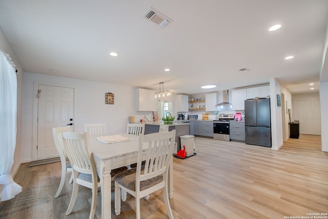 dining area featuring an inviting chandelier and light wood-type flooring