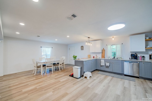 kitchen featuring light wood-type flooring, a wealth of natural light, kitchen peninsula, and stainless steel appliances