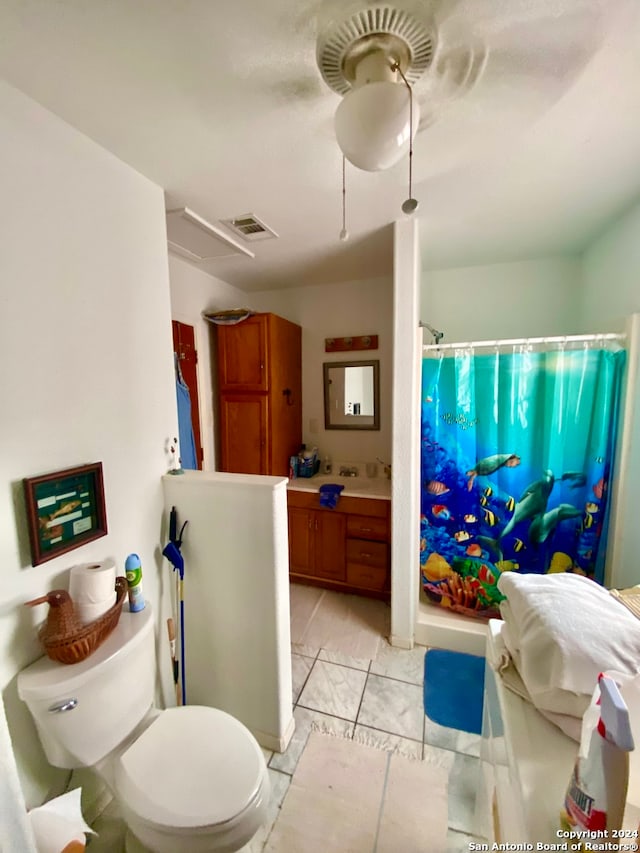 bathroom featuring tile flooring, vanity, and toilet