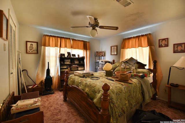 carpeted bedroom with ceiling fan and a closet