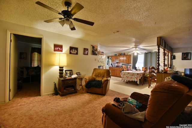 carpeted living room featuring ceiling fan and a textured ceiling