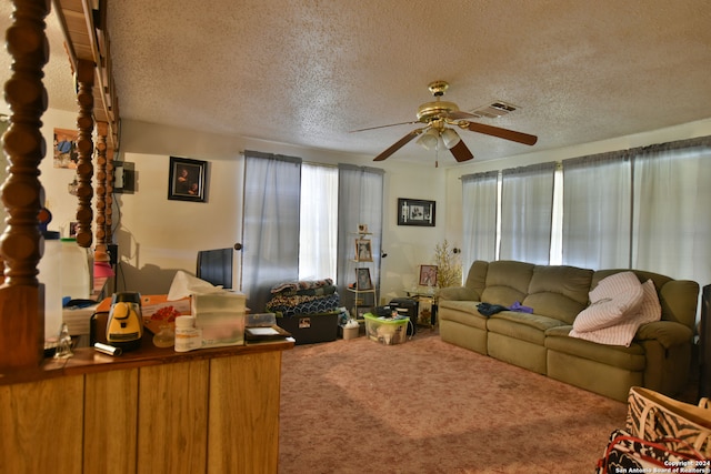 carpeted living room featuring a textured ceiling and ceiling fan