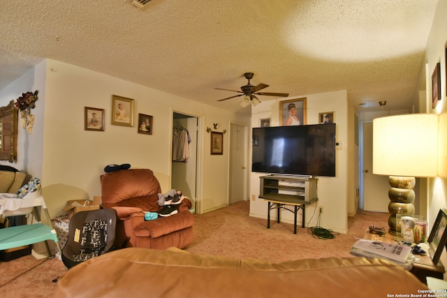 carpeted living room with ceiling fan and a textured ceiling