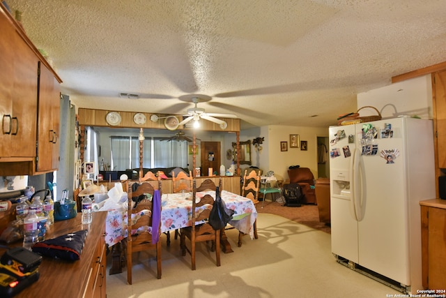 carpeted dining area featuring ceiling fan and a textured ceiling