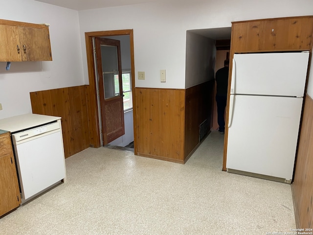 kitchen with white appliances and wooden walls