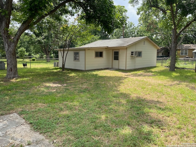 exterior space with a lawn and a wall unit AC