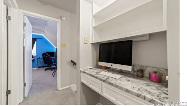 interior space with light stone counters, light carpet, and white cabinetry