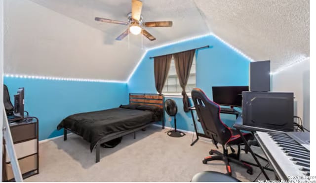 bedroom featuring ceiling fan, vaulted ceiling, a textured ceiling, and light carpet