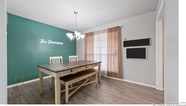 dining room featuring a notable chandelier, hardwood / wood-style flooring, and a textured ceiling