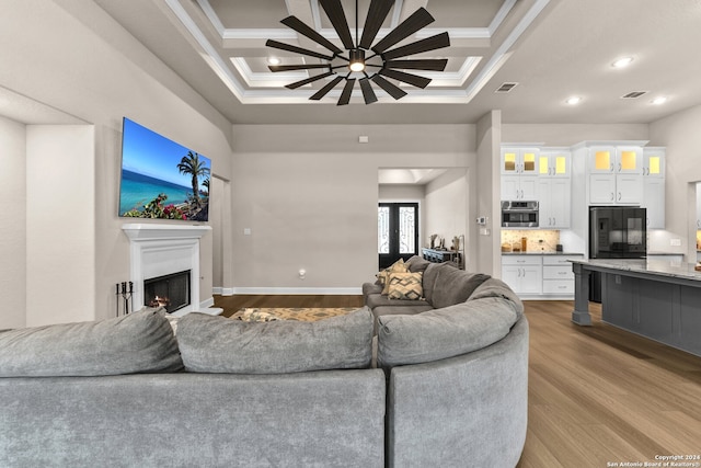 living room with coffered ceiling, crown molding, and wood-type flooring