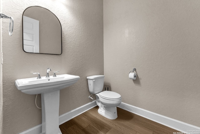 bathroom with hardwood / wood-style floors and toilet