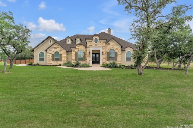 french country inspired facade featuring a front yard