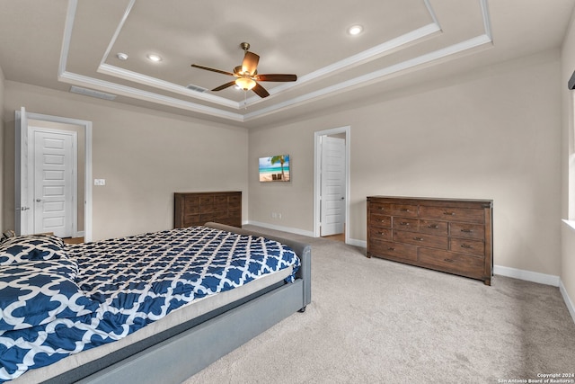 carpeted bedroom featuring ceiling fan and a raised ceiling