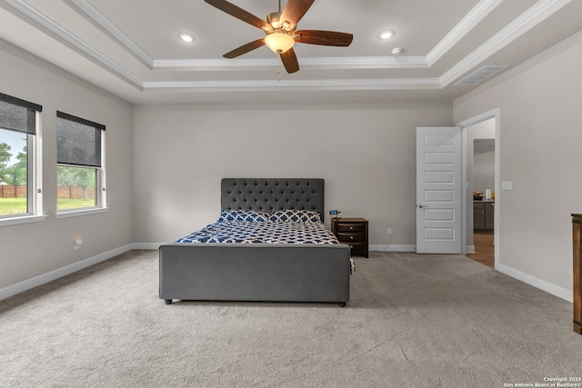 carpeted bedroom with crown molding, ceiling fan, and a raised ceiling