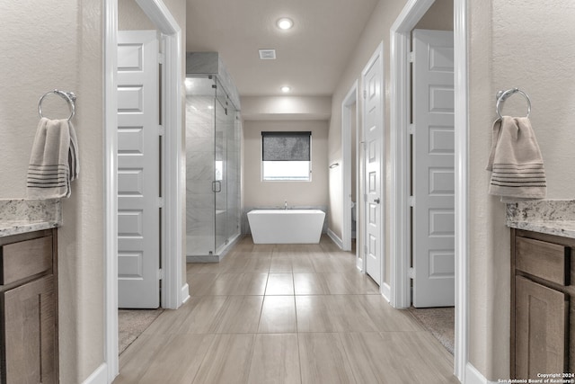 bathroom with tile floors, a shower with door, and vanity