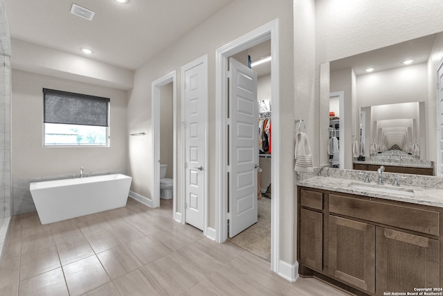 bathroom with tile flooring, vanity, and toilet