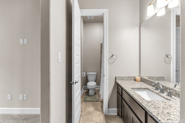 bathroom with tile flooring, toilet, and oversized vanity