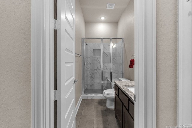 bathroom featuring an enclosed shower, vanity, toilet, and tile floors