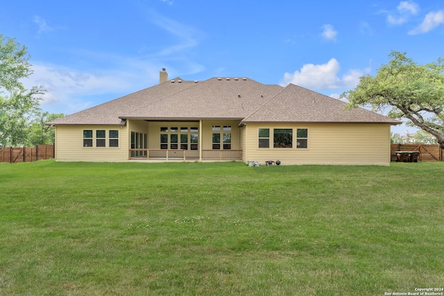 back of house featuring a lawn