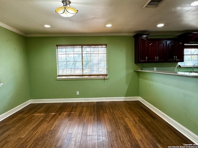 empty room with dark hardwood / wood-style floors and crown molding