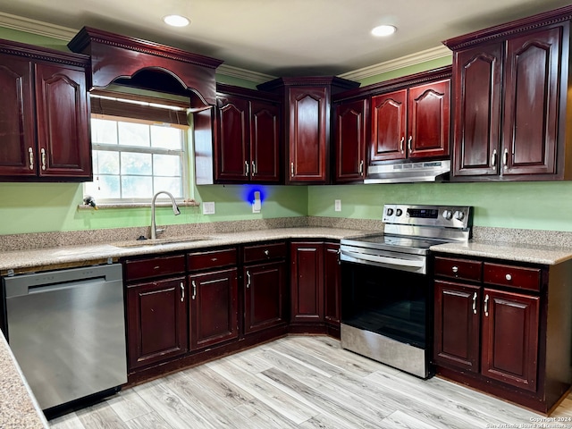 kitchen with stainless steel appliances, light hardwood / wood-style floors, sink, and ornamental molding