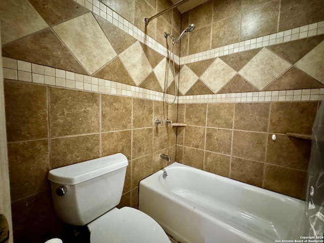 bathroom with toilet, tiled shower / bath combo, and tile walls