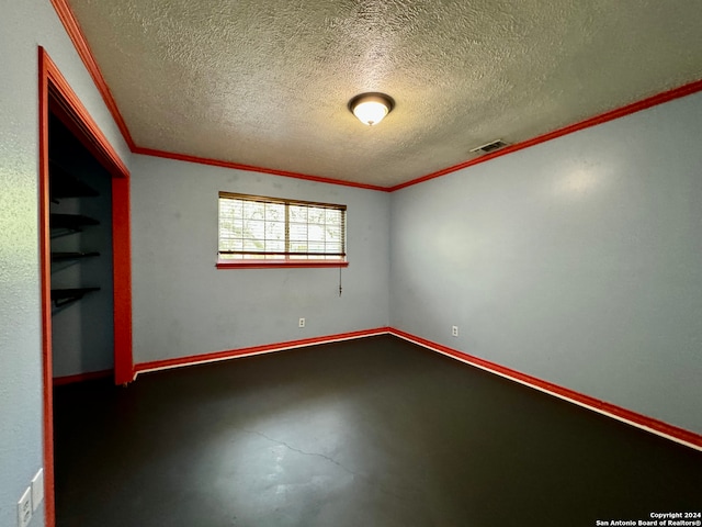 spare room featuring a textured ceiling and crown molding