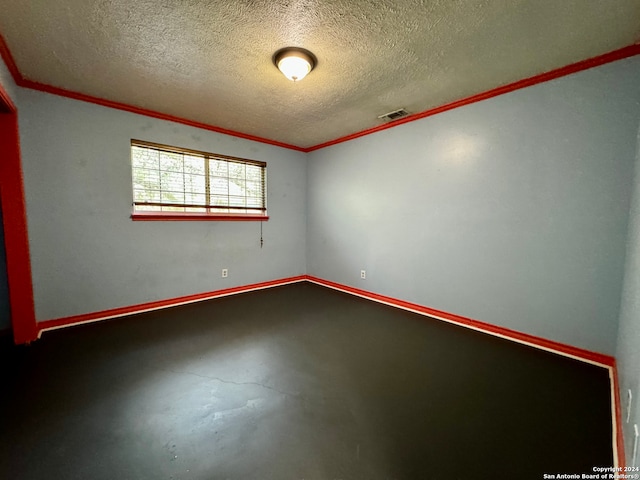 unfurnished room featuring concrete floors, a textured ceiling, and crown molding