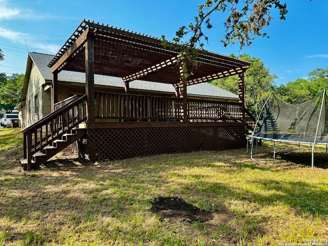 view of yard with a pergola, a wooden deck, and a trampoline