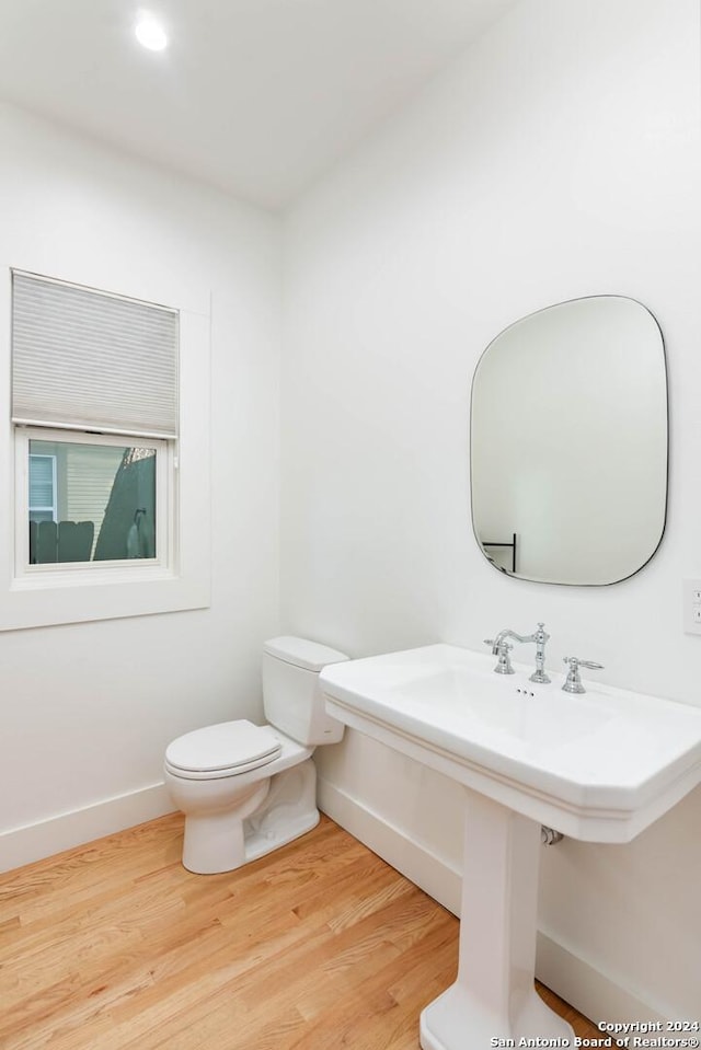 bathroom with hardwood / wood-style floors and toilet