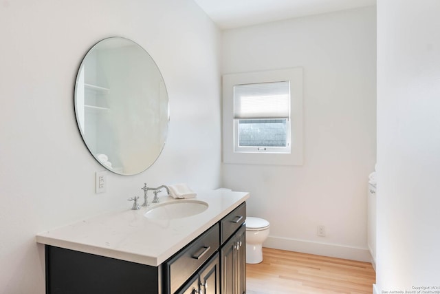 bathroom with hardwood / wood-style floors, vanity, and toilet