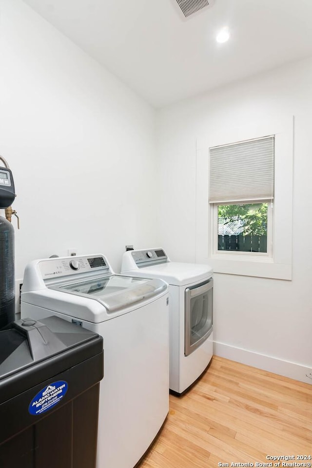 washroom featuring washer and clothes dryer and light hardwood / wood-style floors