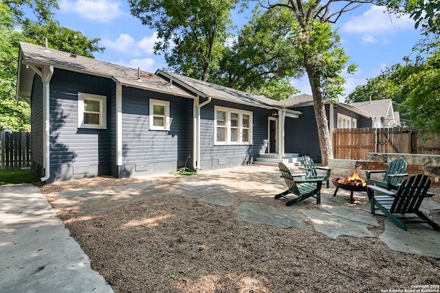 rear view of house with a patio and an outdoor fire pit