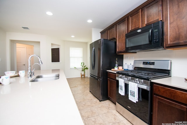 kitchen featuring stainless steel appliances, tasteful backsplash, dark brown cabinets, sink, and light tile floors