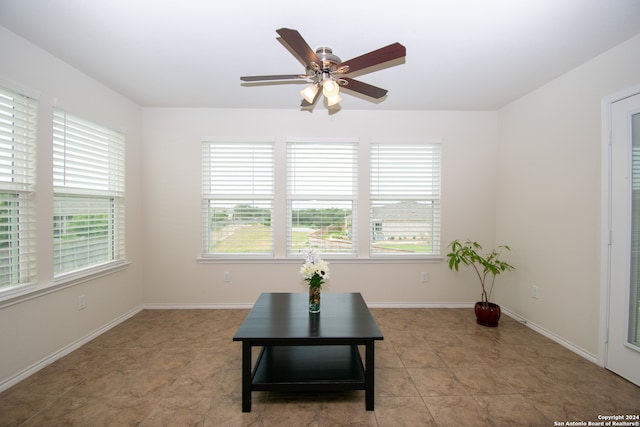 living area with tile floors, plenty of natural light, and ceiling fan