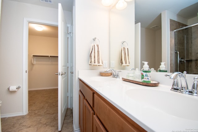 bathroom with tile floors, walk in shower, and double sink vanity