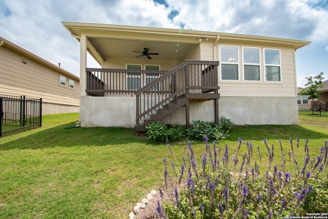 back of house featuring a yard and ceiling fan