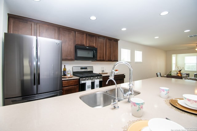 kitchen featuring stainless steel appliances, sink, ceiling fan, and dark brown cabinetry