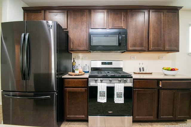 kitchen featuring stainless steel appliances, dark brown cabinets, light tile flooring, and tasteful backsplash