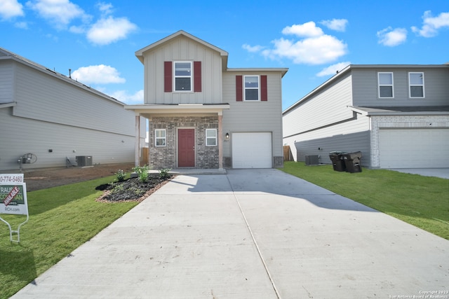 view of front of house featuring a front lawn, a garage, and central air condition unit