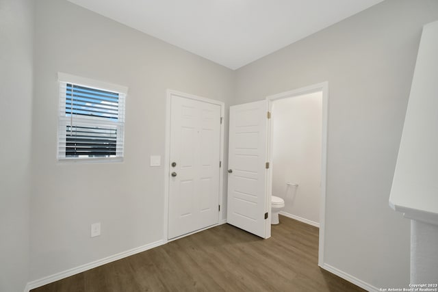 unfurnished bedroom with connected bathroom and hardwood / wood-style flooring